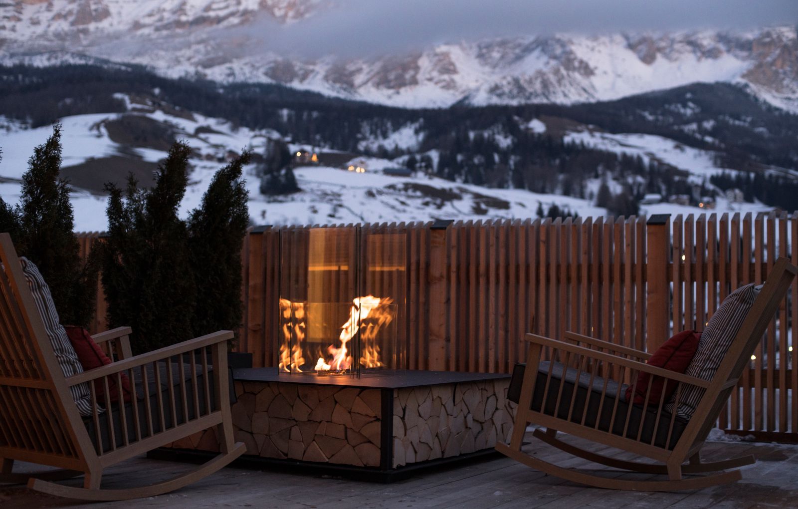 Hotel La Majun, La Villa - views of the Dolomites from the hotel terrace with armchairs next to the fire