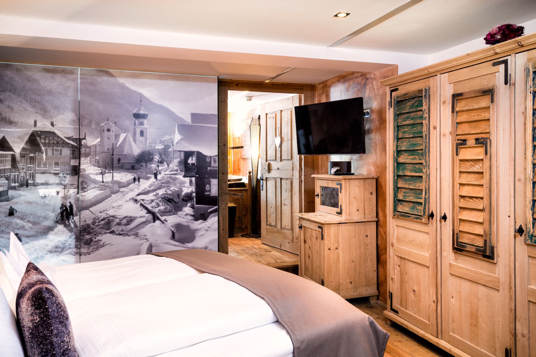 Raffl's St Antoner Hof, St Anton - modern double room with TV and images of skiers on the wall