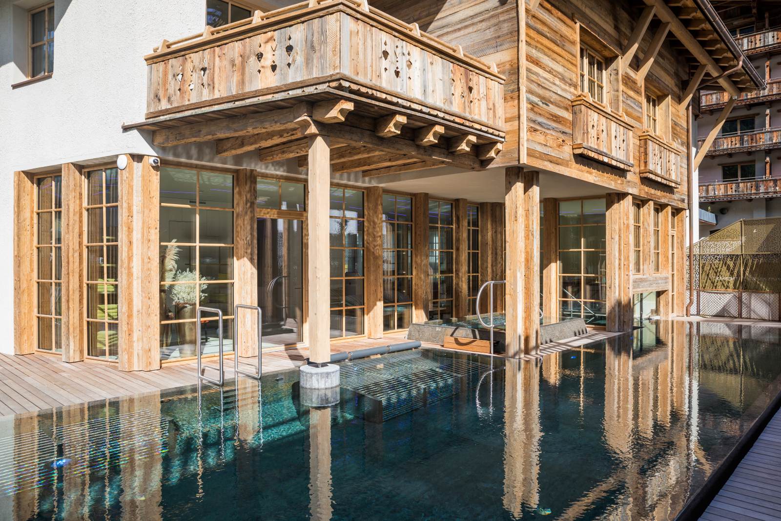 Raffl's Tyrol Hotel, St Anton - hotel exterior in traditional chalet style with outdoor pool