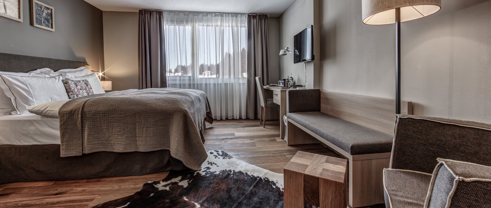 Valbella Resort Lenzerheide - modern suite with double bed and armchair