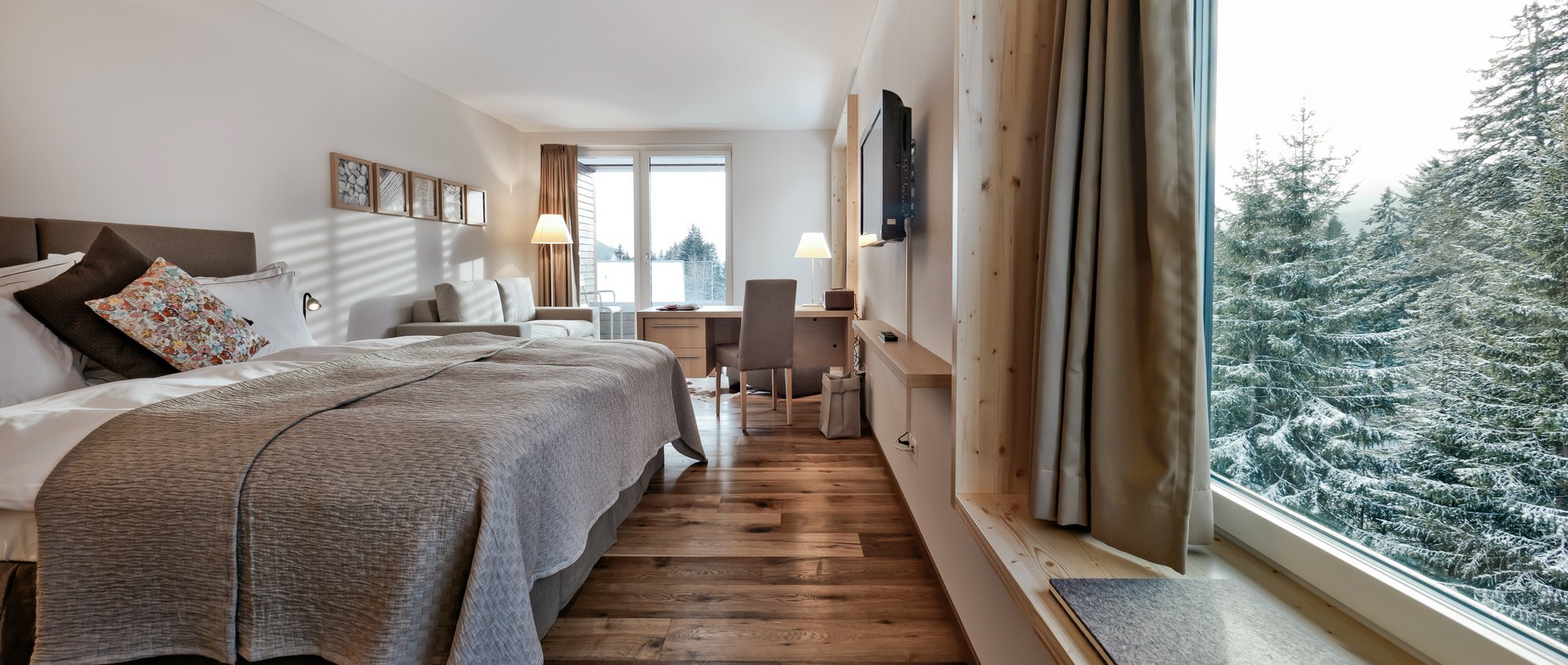 Valbella Resort Lenzerheide - modern bedroom with views of snow-covered trees