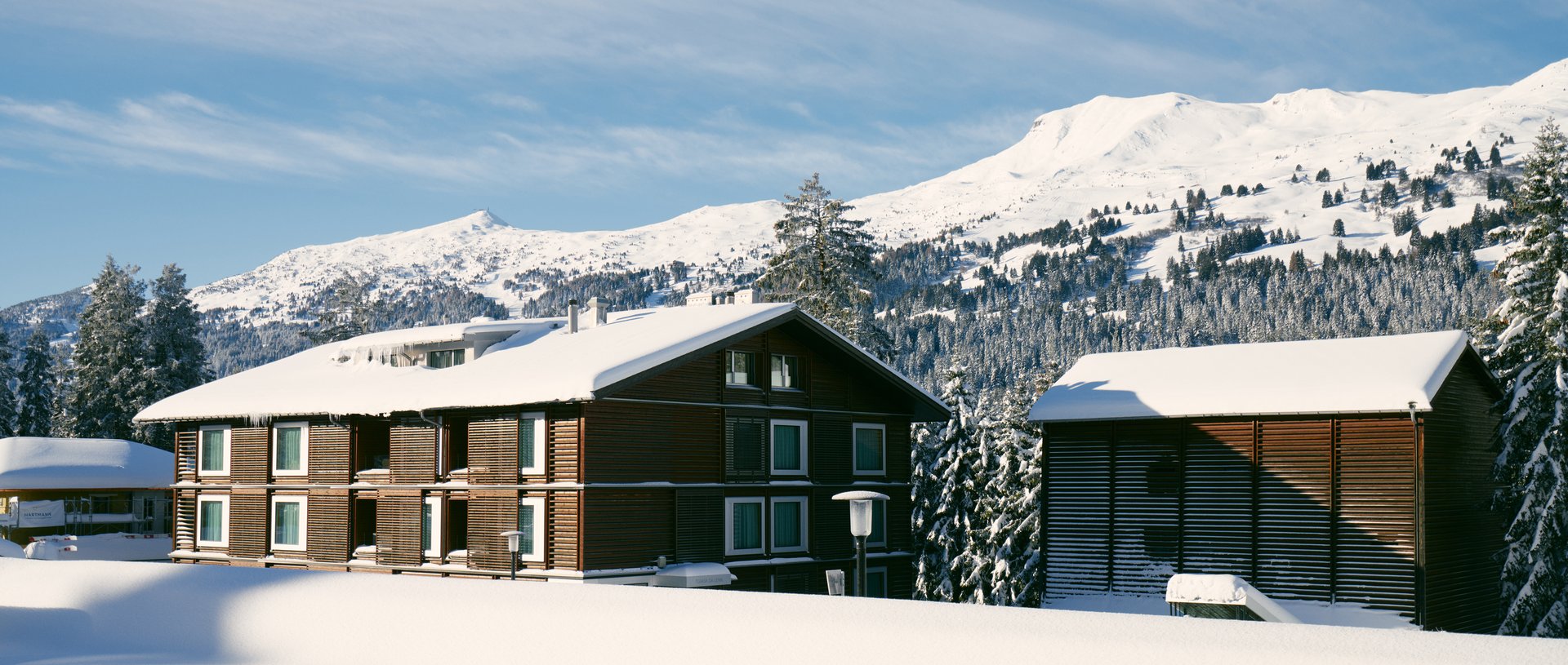 Valbella Resort Lenzerheide - resort exterior with snow-capped mountains behind