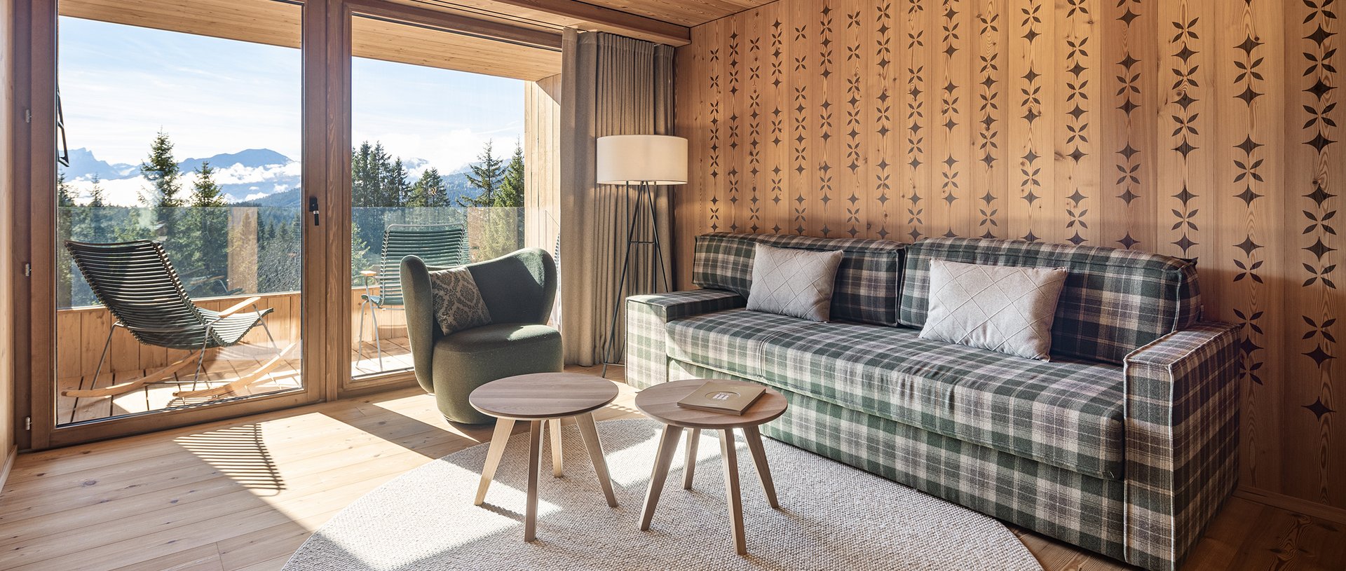 Valbella Resort Lenzerheide - bright suite with sofa, armchair and balcony with mountain views
